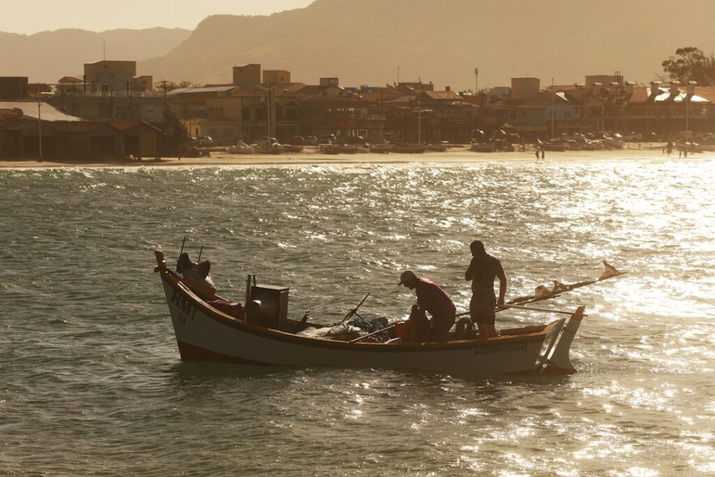 Barcos de pesca artesanal no litoral, referência à Festa da Tainha